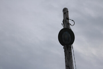 Fototapeta premium Old wooden utility pole and dark sky