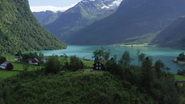 Norwegian lake in aerial 4k drone shot. Beautiful Oldevatnet with turquoise glacier water. landscape with snow on mountain top in summer time