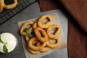 Fried onion rings served on grey table, flat lay