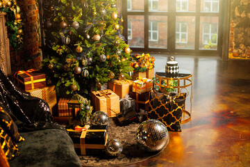 Close-up of a Christmas tree decorated with gold balls. Under the Christmas tree a large number of Christmas gifts. Christmas holiday concept