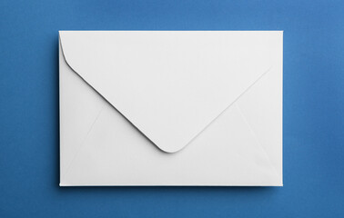 White paper envelope on blue background, top view