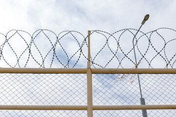 the territory is guarded by a high fence with barbed wire