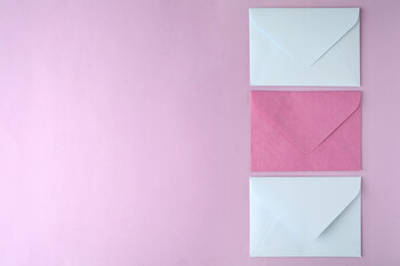 Colorful paper envelopes on pink background, flat lay. Space for text