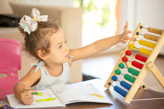 Little girl with abacus and coloring book.