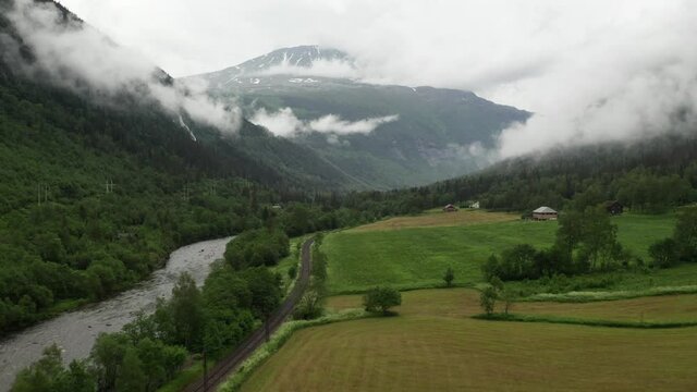 Gaustatoppen aerial drone view from Rjukan valley flying towards mountain peak. Beautiful cloudy morning in summer time