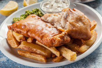Fish in beer batter and chips with green pea and tartar sauce