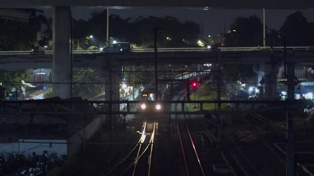 View Of An Approaching KRL Train At The Kebayoran Station In Jakarta, Indonesia At Night - high angle shot