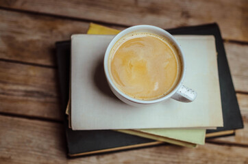 Still Life composition.White cup of coffee and .marshmallow on old books on the wooden background