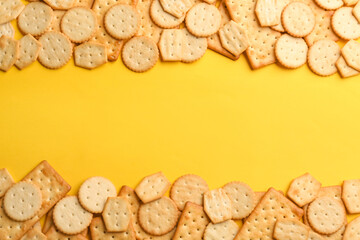 Delicious crackers on yellow background, flat lay. Space for text