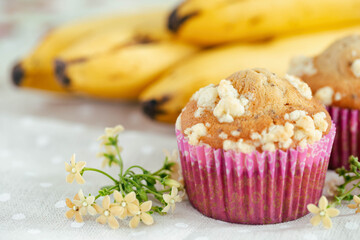 Piece of banana crumble and sesame cupcake or muffin in mini pink cup on table with copy space. Banana cupcake topping with crumbles so sweet and tasty. Homemade bakery with simply delicious concept.