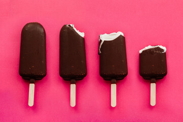 creamy Popsicle on a pink background. the process of eating ice cream