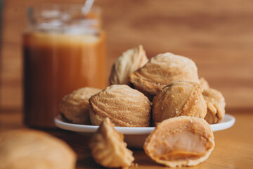 cookie in the form of walnuts stuffed with condensed milk on a wooden background with place for your text