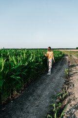 young woman in a corn field in a yellow t-shirt with a place under the text with short hair