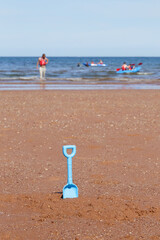 Children shovel toy on the sandy beach