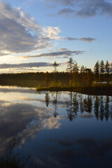 Late summers evening in Finland. Haltiajärvi, Salla. Calm water, cloudlets in the sky, fading light, reflection from water
