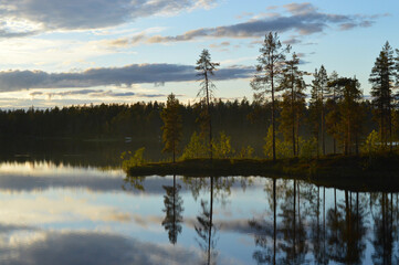 Late summers evening in Finland. Haltiaj&auml;rvi, Salla. Calm water, cloudlets in the sky, fading light, reflection from water