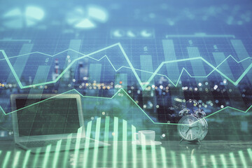 Stock market chart hologram drawn on personal computer background. Double exposure. Concept of investment.