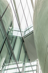 Beautiful architecture business office building. Abstract closeup of the glass-clad facade of a modern landmark covered in reflective plate glass. High tech design, futuristic look, soft natural light