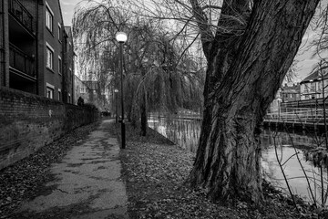 Black and white photo of the waterside footpath along the River Wensum in the city of Norwich, Norfolk