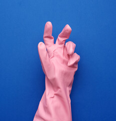 pink rubber glove for cleaning dressed on a female hand