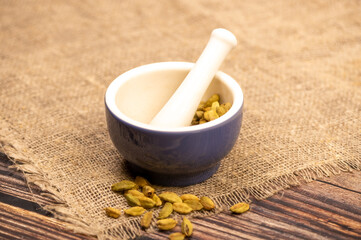 Cardamom in a ceramic mortar and pestle, close-up, selective focus.