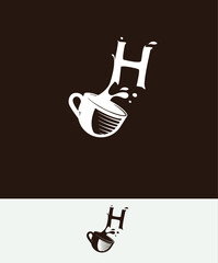 a cup of coffee with the letter H spilled