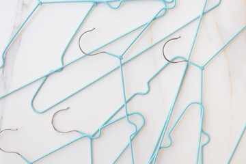 Shopping concept. A set of empty hangers await a wardrobe update. Buying new clothes, changing your image. Blue clothes hangers on white background