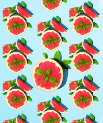 Concept lots of juicy slices of grapefruit and green Basil on a bright blue paper background. Pattern