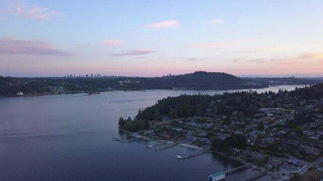 Vancouver Ocean front homes of the rich filmed in drone aerial view at sunset. Beautiful mansions with dock, pier along the sea. Private boats and pools on a little hill British Columbia. Pacific.