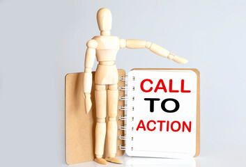 Wooden man shows with a hand to white notepad with text CALL TO ACTION