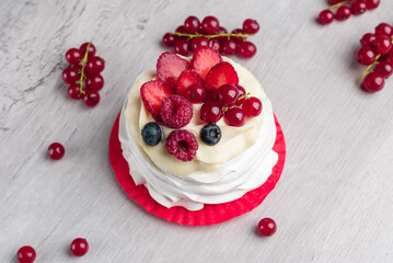 Pavlova meringue cake with cream and raspberries, blueberries, strawberries, currants