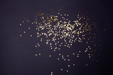 Gold stars decor on a black background. View from above