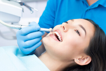 Naklejka premium Dentist and patient in the dental office. Woman having teeth examined by dentists