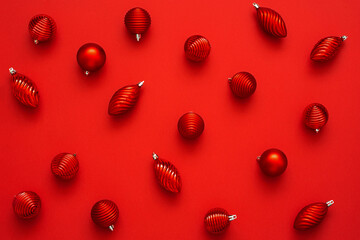 Top view of  red christmas ornaments in different shapes on the red background. New year pattern.