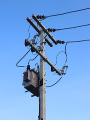 Electrical transformer to electrical concrete pole against the blue sky