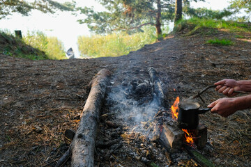 Brewing morning coffee on a campfire. Morning sun. Lake Lyubyaz, Volyn, Ukraine.