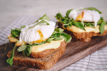 Delicious sandwiches with arugula and egg on wooden board, closeup