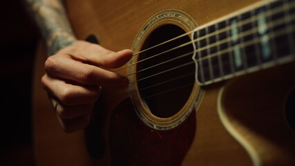 Obraz premium Unrecognizable person rehearsing in music studio. Man hand playing guitar.