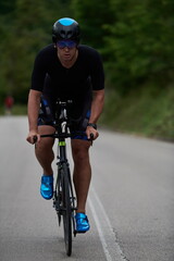Fototapeta na wymiar triathlon athlete riding a bike wearing black