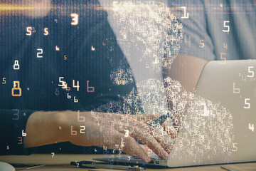 Technology theme hologram with man working on computer on background. High tech concept. Multi...