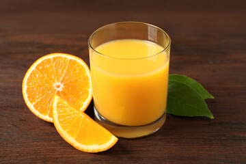 Glass of orange juice and fresh fruits on wooden table, closeup