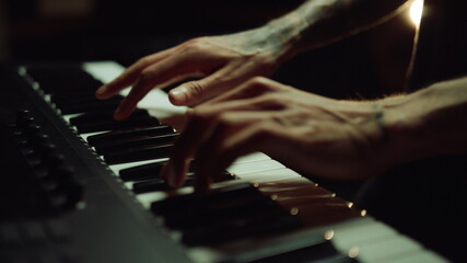 Man hands pressing keys on piano in recording studio. Musician making song.