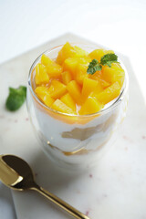 Tasty peach dessert with yogurt served on white table