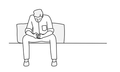 Young man is sitting on sofa and using phone.