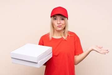 Pizza delivery Russian woman holding a pizza over isolated wall making doubts gesture while lifting the shoulders