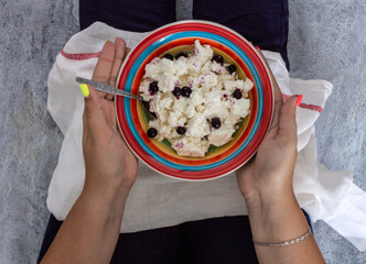 a plate with cottage cheese in the hands of a girl