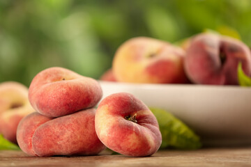 Fresh ripe donut peaches on wooden table, closeup
