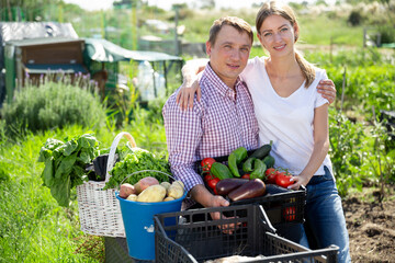 Joyful couple with a basket of vegetables in the garden. High quality photo