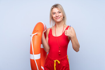 Lifeguard woman over isolated blue background with lifeguard equipment and with thumbs up