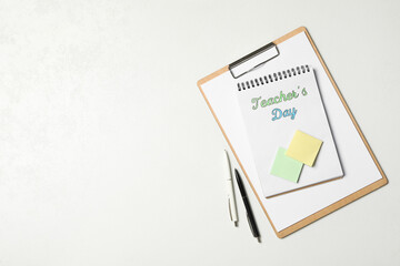 Stationery and words TEACHER'S DAY on white background, flat lay. Space for text